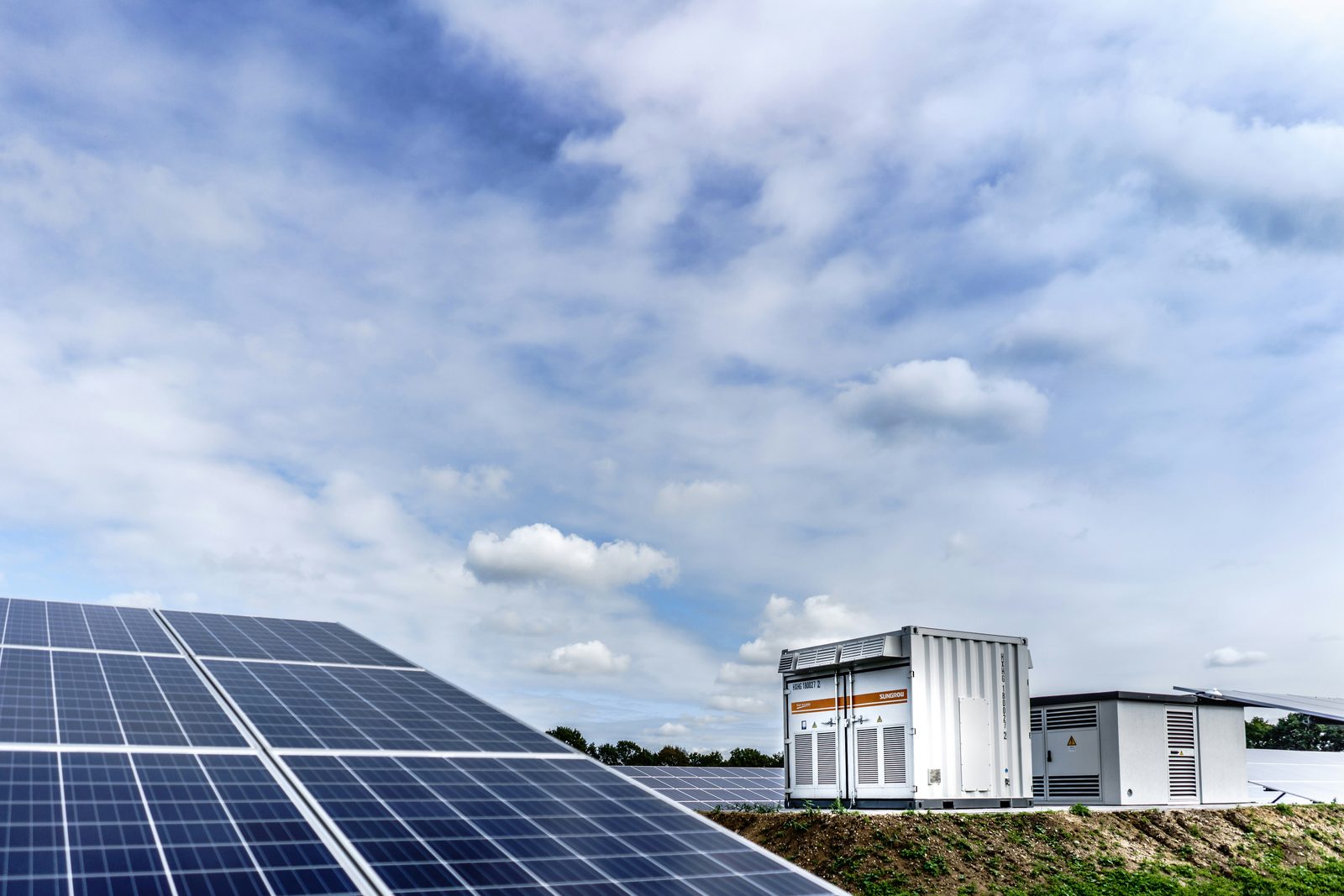 Sistem de stocare BESS în containere, lângă panourile unui parc fotovoltaic